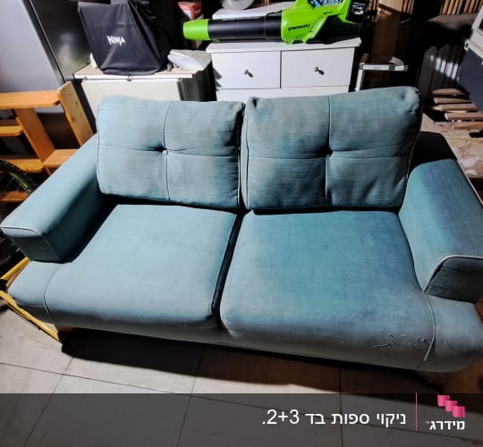 ספה כחולה בחדר עם כלים שונים סביב
